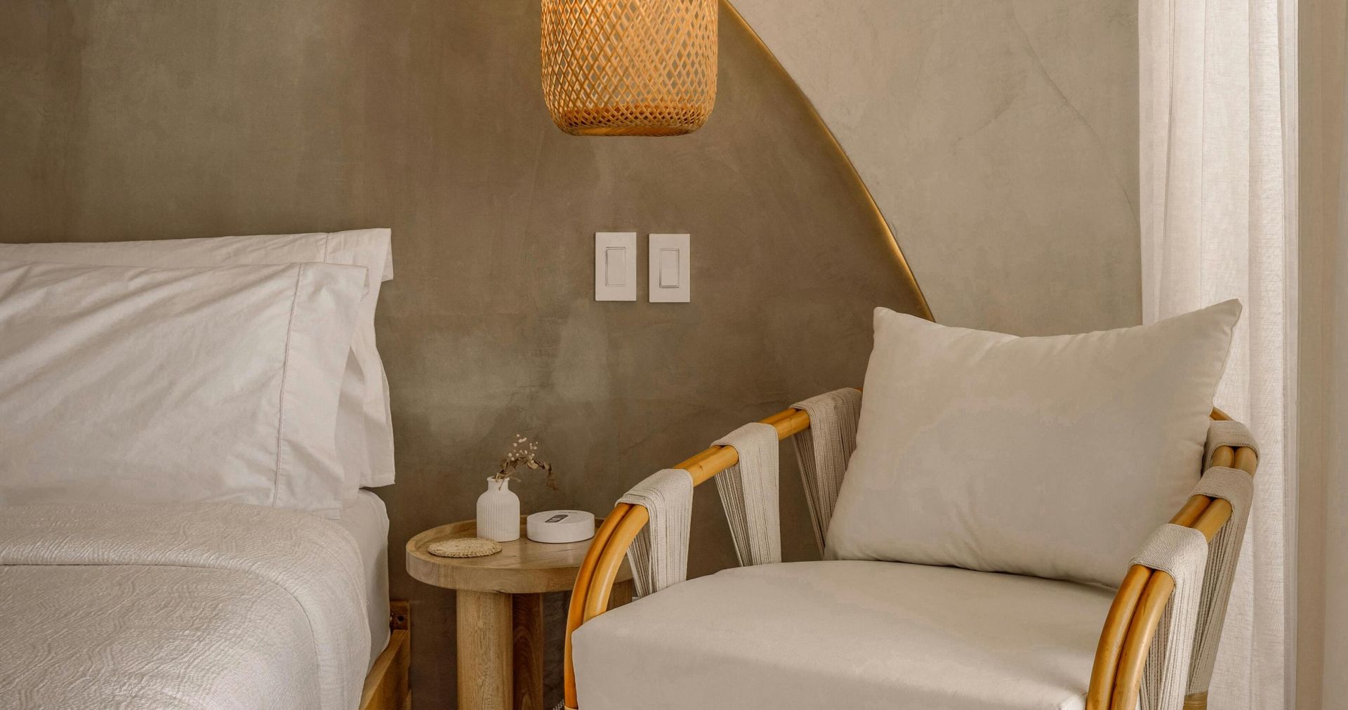 Chic bedroom interior featuring rattan furniture and warm lighting for a soothing ambiance.